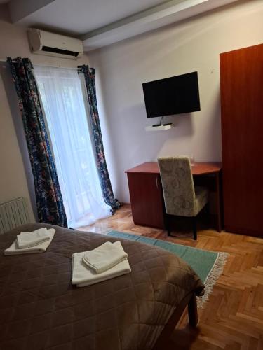 a bedroom with a bed and a desk and a television at Hotel Koliba na Grza in Kilsura