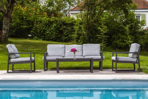 two chairs and a bench next to a swimming pool at La Fernandiere, Historic Home, Garden and Pool in Saint-Georges-sur-Cher