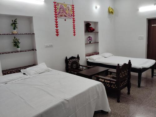 una habitación con dos camas y una mesa y sillas en Krishna Marriott, en Jodhpur