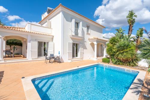 a villa with a swimming pool in front of a house at Captivating Villa 600M to Vau Beach in Vau