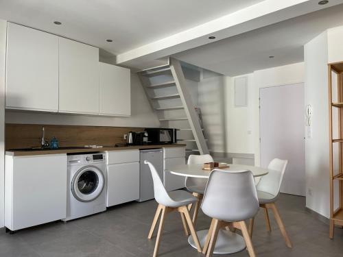une cuisine avec une table et une machine à laver dans l'établissement Duplex en centre ville de GAP, à Gap