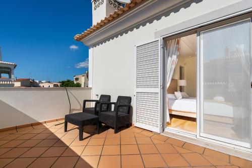 a balcony with two chairs and a bed at Captivating Villa 600M to Vau Beach in Vau