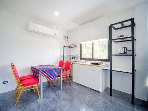 a kitchen with a table and two chairs and a counter at Los Patios Hostel Phuket in Mai Khao Beach