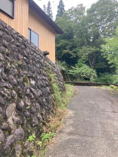 a stone retaining wall next to a house at 山斎ｰ勝山市の最北端に佇む一棟貸しの宿- in Katsuyama