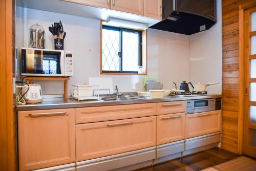 a kitchen with wooden cabinets and a sink at 山斎ｰ勝山市の最北端に佇む一棟貸しの宿- in Katsuyama