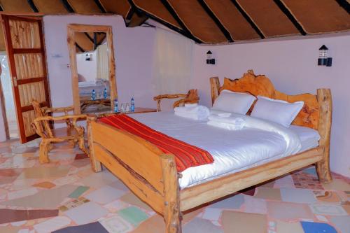 a bedroom with a large wooden bed in a room at Enkapune Resort Naivasha in Naivasha