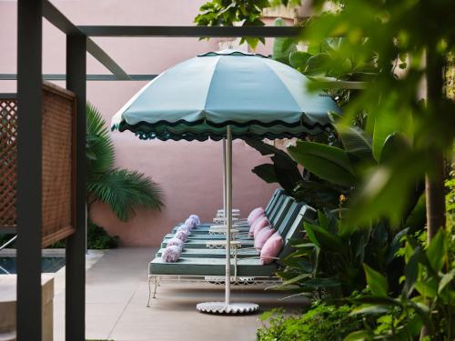 a patio with a blue umbrella and a bench at Domus Blanc Boutique Hotel in Chania Town