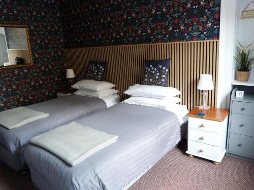 two beds in a hotel room withskirts at Wee Ness Cottage in Inverness