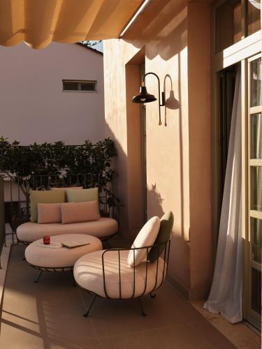 a patio with a couch and chairs on a balcony at Domus Blanc Boutique Hotel in Chania Town