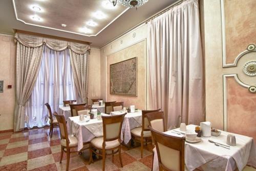 a restaurant with tables and chairs in a room at Hotel Pedrini in Bologna