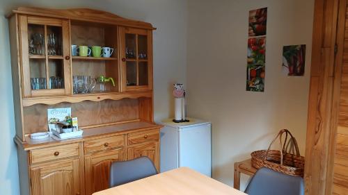 a kitchen with a wooden hutch and a refrigerator at Nordseeferienhaus Peter in Niebüll