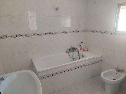 a bathroom with a tub and a toilet and a sink at Dehesilla Olive Orchard Retreat in Fuentes de Cesna