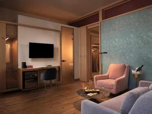 a living room with a couch and a table and a tv at Domus Blanc Boutique Hotel in Chania Town