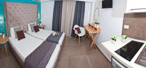 a small room with two beds and a kitchen at Malibu Boutique Studios & Bungalows in Faliraki