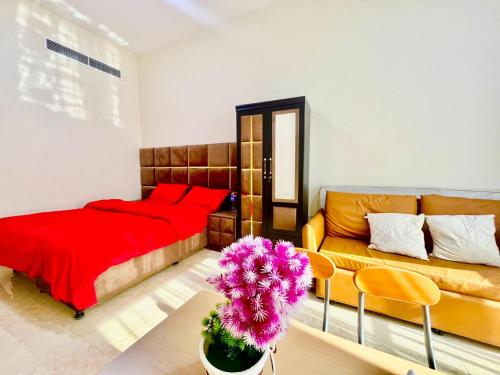 1 dormitorio con cama roja y sofá en Haifa building, en Dubái