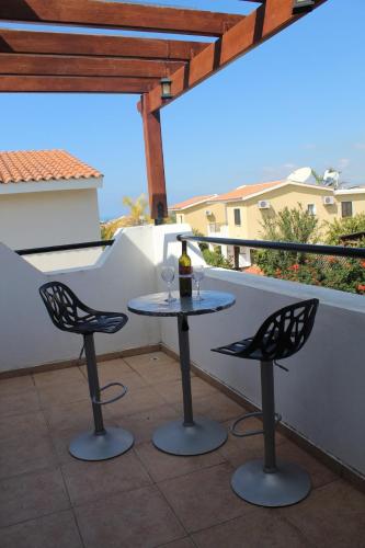 a table with two chairs and a bottle of wine on a balcony at Villa Kalandia in Emba