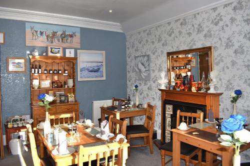 a dining room with two tables and a fireplace at Kilbrannan Guest House in Great Yarmouth