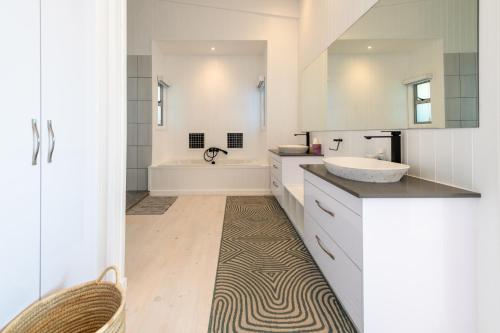 a bathroom with a sink and a tub at Dolphin View Beach Villa in Sedgefield