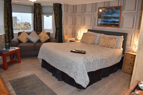 a bedroom with a large bed and a couch at Kilbrannan Guest House in Great Yarmouth