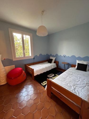 une chambre avec deux lits et une fenêtre dans l'établissement Le Paradis au centre du Vaucluse, à Saumane-de-Vaucluse