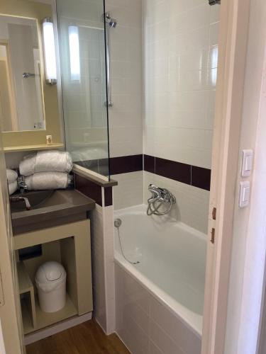 une salle de bain avec une baignoire et un lavabo dans l'établissement Cap Esterel C9 - Studio cabine avec terrasse et parking privatif, à Saint-Raphaël