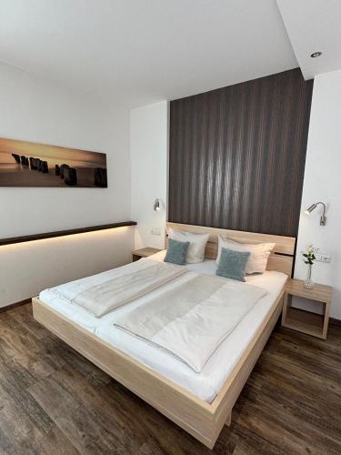 a bedroom with a large bed with white sheets and blue pillows at Alte Postvilla in Oberammergau