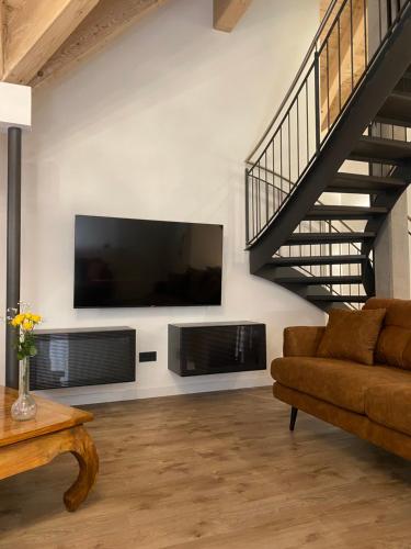 a living room with a couch and a tv on a wall at Alte Postvilla in Oberammergau