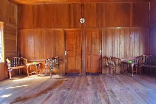 an empty room with three chairs and a clock on the wall at Villa Zoya 1 in Bogor