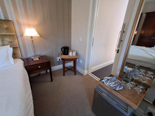 a hotel room with a bed and a table with a mirror at Wild Mushroom Country House in Stellenbosch