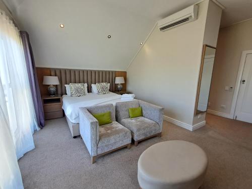 a bedroom with a bed and a couch and a chair at Wild Mushroom Country House in Stellenbosch