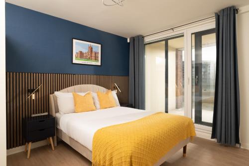 a bedroom with a king sized bed with blue walls at River Side Apartment, City Centre - Beautiful View and Free Parking! in Belfast