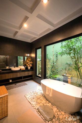 a large bathroom with a tub and a large window at Likha Wellness Resort in Lipa