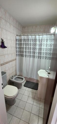 a bathroom with a toilet and a shower and a sink at Casa Pino in Río Gallegos