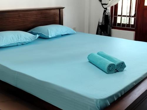 a large bed with blue pillows on it at WR Family and Holiday Resort in Anuradhapura