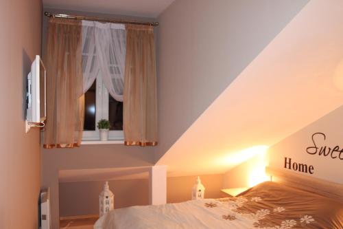 1 dormitorio con cama y ventana en Carmen Apartment, en Cracovia