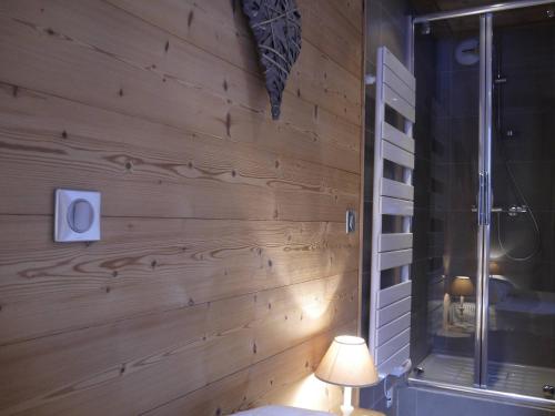 a bathroom with a wooden wall with a lamp and a shower at Appartement Méribel Mottaret 3 chambres, proche pistes, Wifi - FR-1-355-98 in Méribel