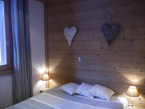 a bedroom with a wooden wall with two hearts on it at Appartement Méribel Mottaret 3 chambres, proche pistes, Wifi - FR-1-355-98 in Méribel