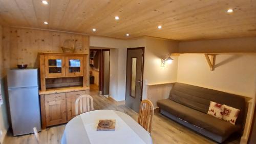 Il comprend une cuisine et une salle à manger avec une table et un réfrigérateur. dans l'établissement CHALET VALLÉE BLANCHE, à Combloux