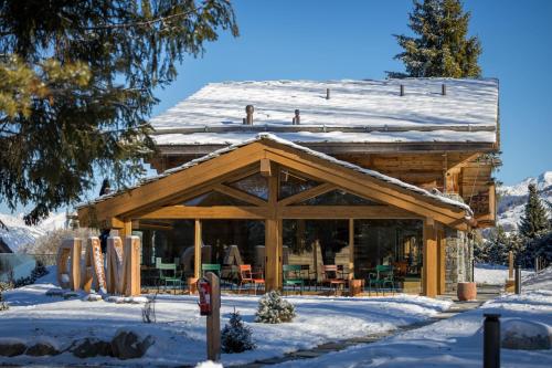 a log cabin with snow on the roof at MAD Retreat Hotel in Nendaz