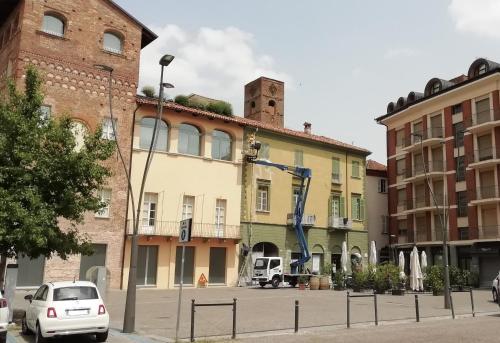 a group of buildings with cars parked in a parking lot at Easy Ray affittacamere in Alba