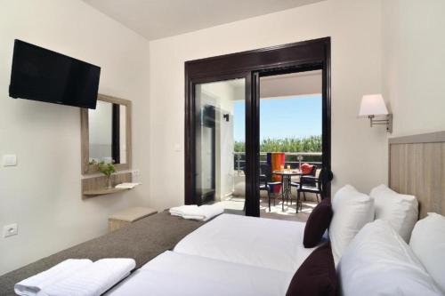 a bedroom with a bed and a view of a patio at Carisa Suites and Apartments in Maleme