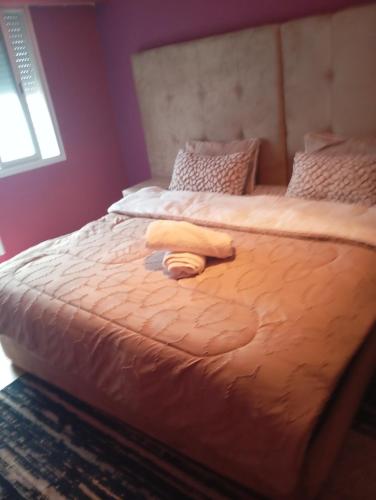 a bed with two towels on top of it at logemois in Rabat