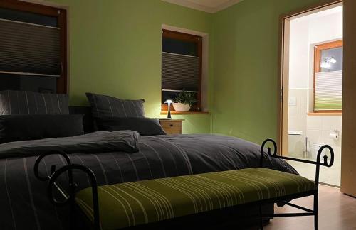 een slaapkamer met groene muren en een bed met een bank bij Spreequartier in Malschwitz