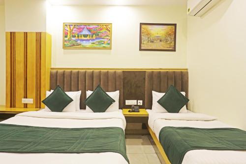 a hotel room with two beds with green sheets at Hotel Aman Imperial Just a Minute Away From New Delhi Railway Station and Connaught place in New Delhi