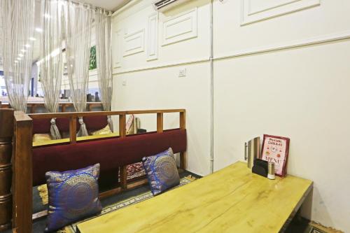 a dining room with a wooden table and a bench at Hotel Aman Imperial Just a Minute Away From New Delhi Railway Station and Connaught place in New Delhi