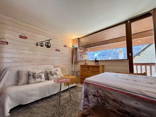 a bedroom with a bed and a large window at Appartement lumineux 2 pièces cabine au Monêtier-les-Bains, proche pistes, avec parking - FR-1-330F-239 in Le Monêtier-les-Bains