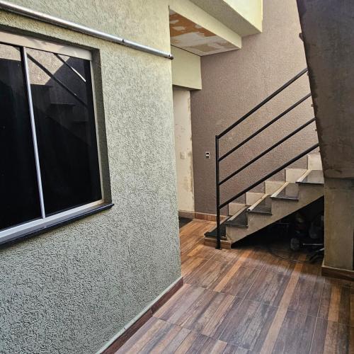 an empty room with a staircase and a window at Loft 14 espaço inteiro segundo andar com ar condicionado e garagem in Salto