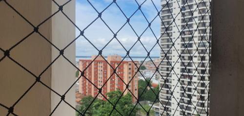 a view of a city through a chain link fence at AP Premium COP30 in Belém