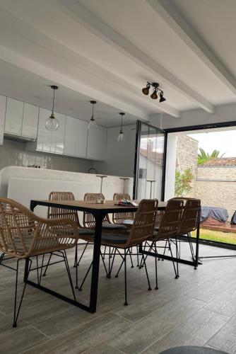 une salle à manger avec une table et des chaises et une cuisine dans l'établissement Spa Village Heart, Near Sea, Charming, Spa May-Sep, au Bois-Plage-en-Ré