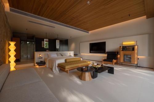 a bedroom with a bed and a living room at Anlai Rainforest Wild Luxury Hotel in Jinghong